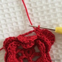 Flor quase finalizada em fio vermelho