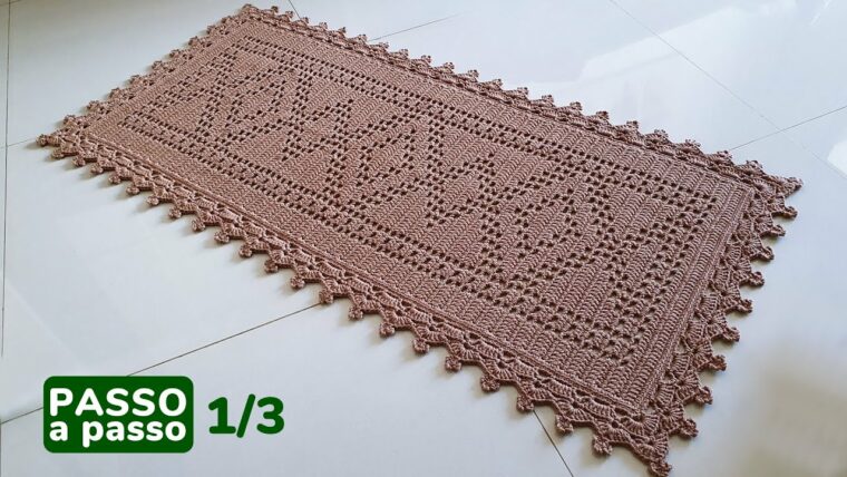 Detalhe de trabalho manual em crochê: Tapete retangular de crochê, cor bege, confeccionado com barbante, pontos altos, baixos e relevo, com borda decorativa e padrão geométrico detalhado. — Produzido por Samuel Ramos - Blog do Crochê.