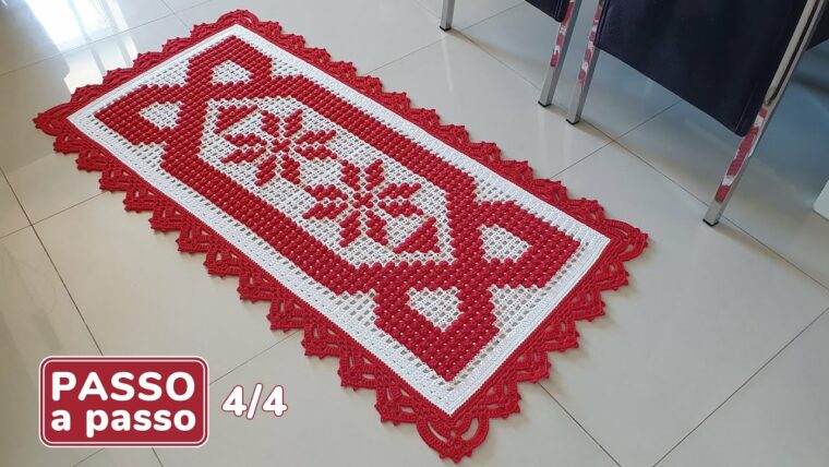 Detalhe de trabalho manual em crochê: Tapete retangular de crochê, ponto alto, fio de algodão, predominância das cores vermelha e branca, detalhes geométricos e borda decorativa. — Produzido por Samuel Ramos - Blog do Crochê.